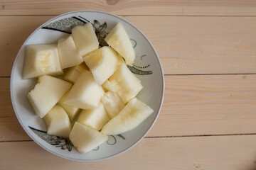 Melon slice on wooden plate with wooden background . On a wooden background in a white plate of Sliced melon .