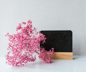 small pink flowers  and black board for writing. copy space - 365012491