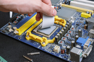 computer motherboard hand smear thermal grease, on the table repair equipment