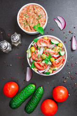 Summer salad with tomatoes, cucumbers, olives and microgreen on a flat lay table