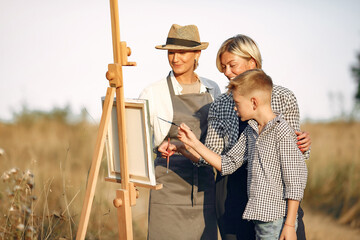 Women in a summer field. Cute familydrawing. Two woman with a son.
