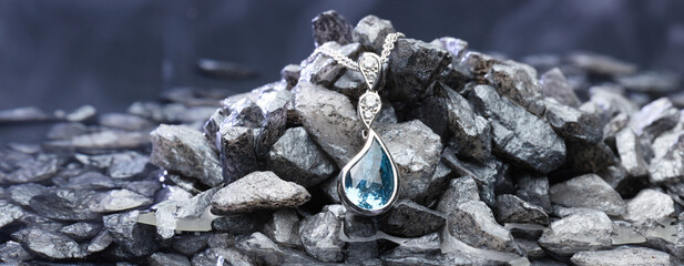 Classy blue drop necklace close-up on top of grey stones