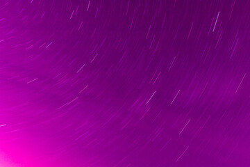 Background of round or circular star track or trajectory on the red, pink or rose clear night sky....