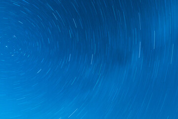 Background of round or circular star track or trajectory on the blue clear night sky. Symbol of...