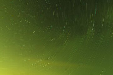 Background of round or circular star track or trajectory on the green clear night sky. Symbol of...