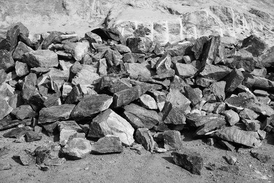 Black and White Image of Pile Of Rocks I.E. Lithium Mining And Natural Resources Like Limestone Mining In Quarry. Natural Zeolite Rocks Are Excavated With Deforestation In Background.