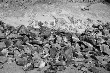 Black and White Image of Pile Of Rocks I.E. Lithium Mining And Natural Resources Like Limestone Mining In Quarry. Natural Zeolite Rocks Are Excavated With Deforestation In Background.