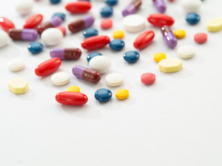 Close up view of different colors pills on white back 