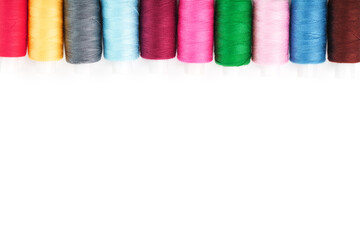 Sewing threads of different colors on reels on a white background. Free space, close-up. Isolate