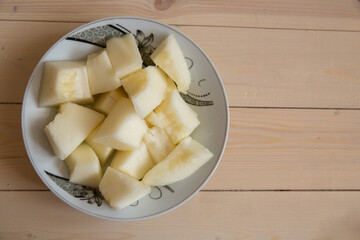 Melon slice on wooden plate with wooden background . On a wooden background in a white plate of Sliced melon .