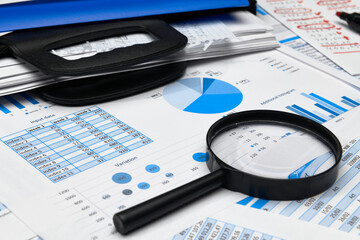 business office desk closeup - financial reports, analysis and accounting, set of documents, tables and graphs, various items for bookkeeping, calculator