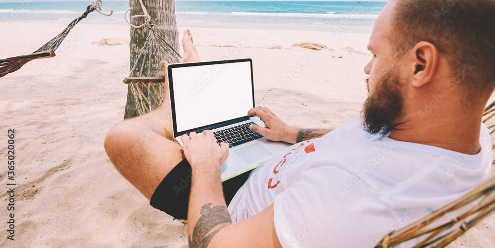 Poster male businessman tourist typing text on keyboard of computer with blank screen for your internet web