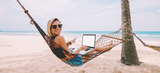 Happy successful female work freelance at laptop with blank screen area for web content while lying...