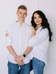 brunette beautiful stylish woman with teen son in white shirts and jeans. Family, style, relative concept