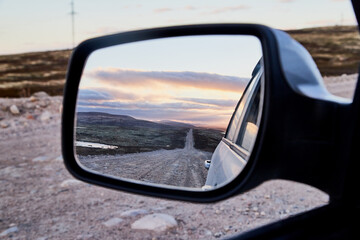 Fototapeta premium Car Mirror and reflection of the road and sky in it.