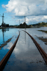 Train tracks in Coos Bay, Oregon under water. Vertical image. 