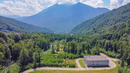Fototapeta premium Infrastructure of a modern city. Aerial view of beautiful futuristic modern water intake pumping wells against the background of mountains and peaks. Sochi, Russia.