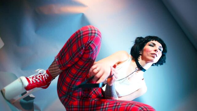 Submissive girl makes dance moves at kinky party. The girl on high heels. Role play concept. Smooth camera rotation.