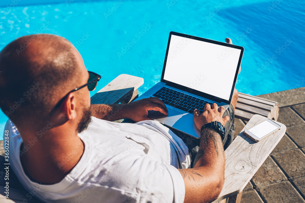 Poster top view of male freelancer searching information on internet websites and working at modern netbook