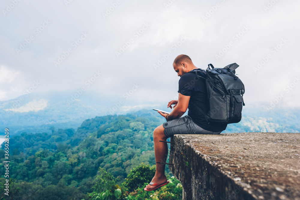 Poster male hiker with backpack sitting on top with beautiful scenery on asia environment with green vegeta