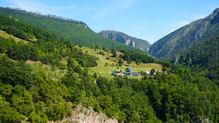 Villas in the mountains. Mountain landscape of a green valley. Holidays in the mountains. Sunny summer day.
