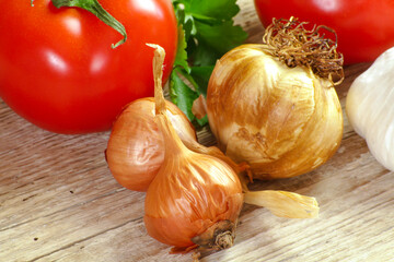 tomatoes, shallots and garlic head on a wooden table