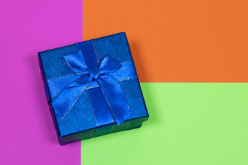 Gift on a multicolored background. Surprise in a festive package.