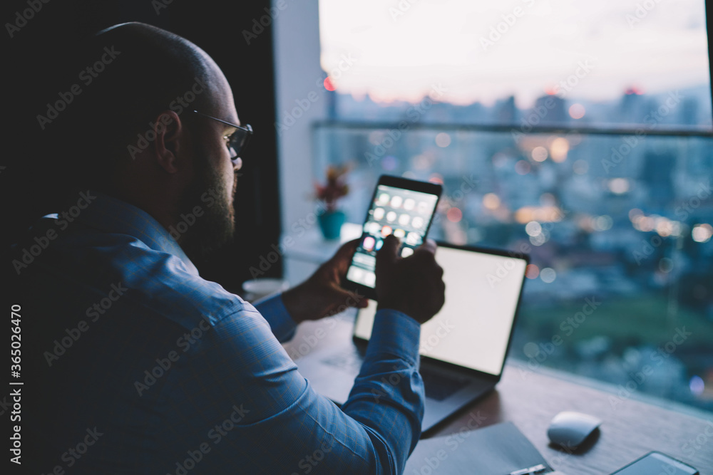Poster male freelancer using modern gadgets during distance work synchronizing tablet multimedia files with