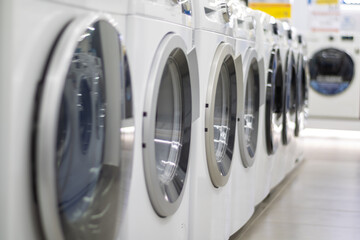 A row of washing machines in the store.