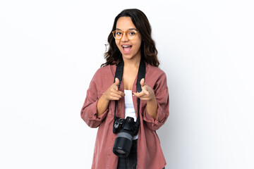 Young photographer woman over isolated white background surprised and pointing front