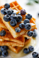 Waffles with fresh blueberries and honey close up view