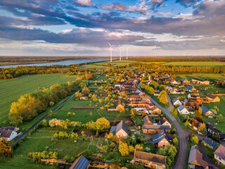 Aerial view over a little town with wind wheels and a lake in the background of a german...