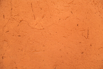 close-up of the clay wall of a terracotta-colored village house, texture