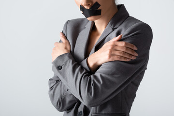 cropped view of businesswoman with scotch tape on mouth standing with crossed arms isolated on...