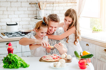 dad with daughters preparing pizza