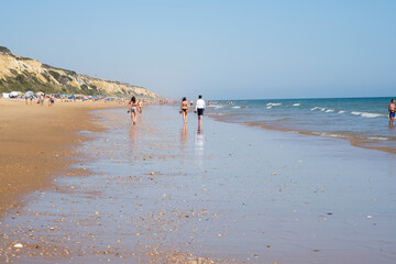 Personas paseando por la playa