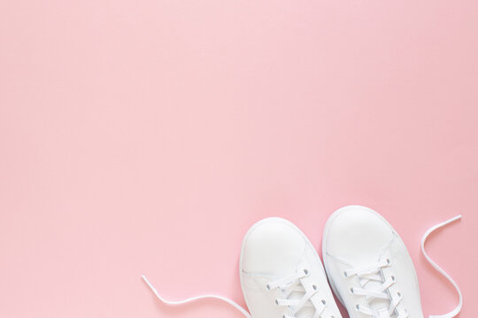 All white sneakers on pink background. Top view,flat lay