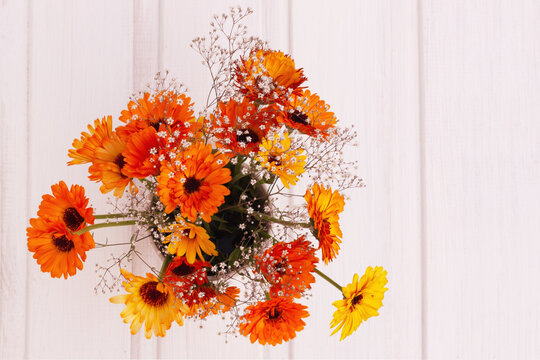Bouquet Of Orange Flowers On A Light Wooden Background. View From Above