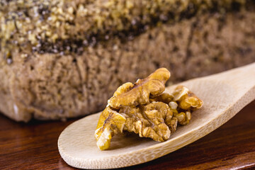 shelled walnut in a rustic wooden spoon, used as an ingredient in vegan bread.