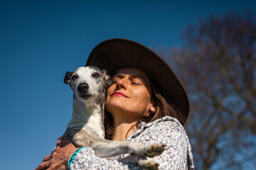 Happy woman love her dog. Friendship between pet owner and her whippet