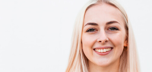 Pretty smiling joyfully female with fair hair, dressed casually, looking with satisfaction at camera, being happy. Studio shot of good-looking beautiful woman