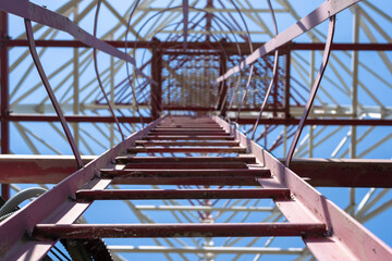 Naklejka premium Cell tower maintenance staircase on a blue sky background.