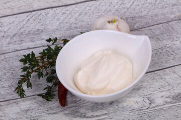 Mayonnaise sauce in the white bowl served thyme and garlic