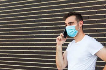 Man with disposable mask talking on phone indoors. Dangerous virus
