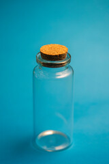 small empty glass container on a blue background