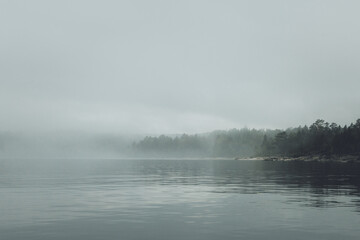 Obraz na płótnie Canvas Fog over the lake. Early morning on Ladoga lake in Karelia, Russia. 