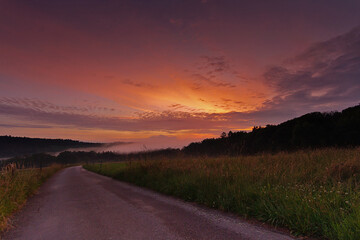 Sonnenuntergang mit Nebel über der Wiese	