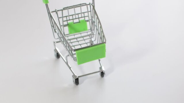 Supermarket trolley with gift bags. White background, place for text. E-commerce concept.