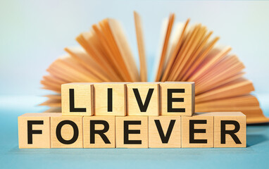 Open book and Wooden cubes with the abbreviation LIVE FOREVER