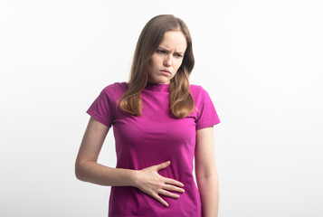 caucasian young woman in violet t-shirt with stomachache during menstruation putting her hands on...